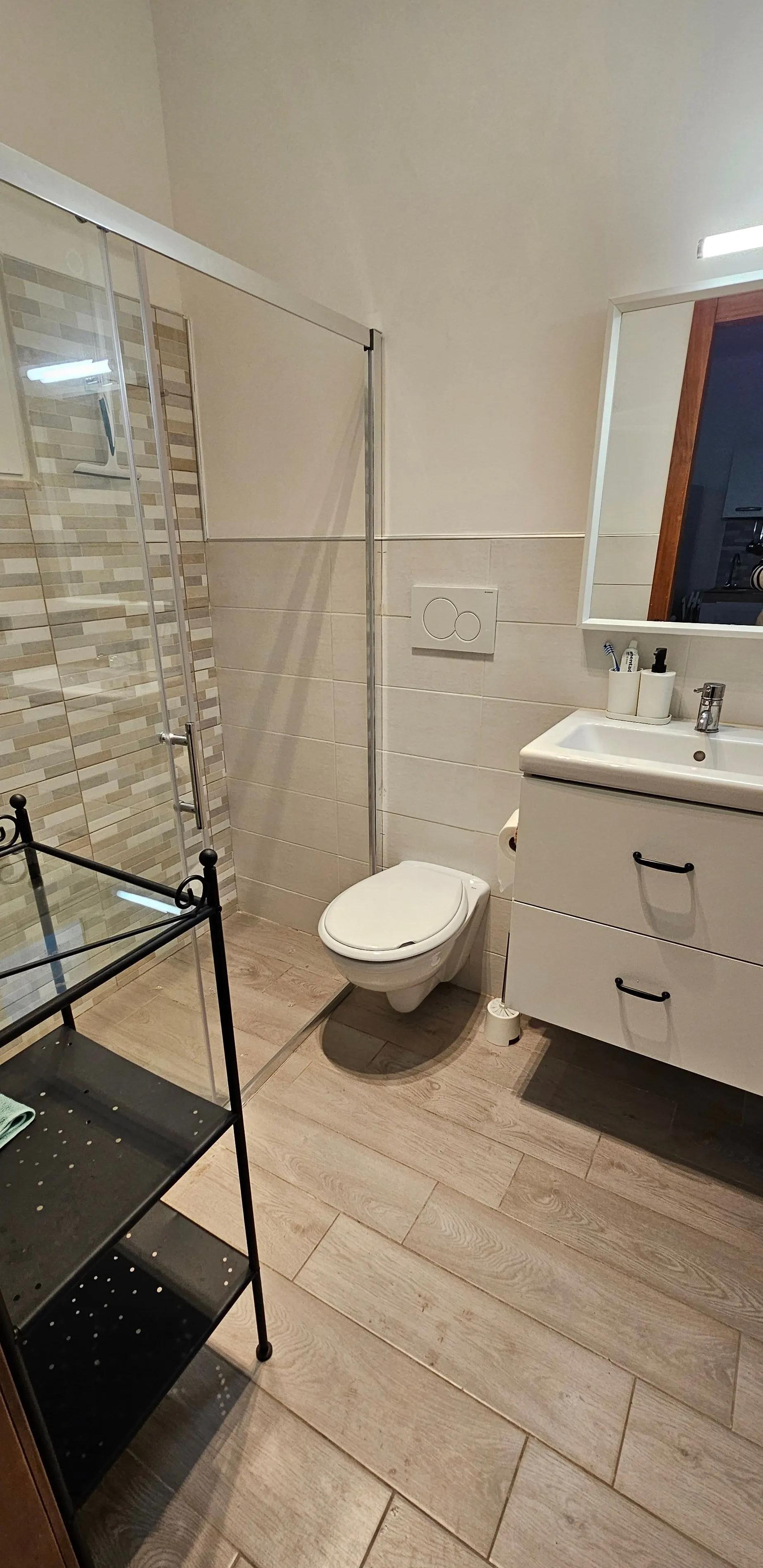 Cabina doccia in vetro, sanitari e ampia vetrata di accesso.